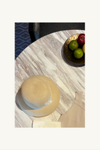 Hélène | Hat | Pauline | 
ナチュラルなラフィア素材に、細いベロアのリボンを品良く巻き付けた端正なストローハット。美しいシルエットが目元に静かな影を落とし、知性と品格で日常を彩る現代の淑女のための帽子。
Captured at Grand Premier Room, Sindhorn Kempinski Hotel Bangkok.
ホテルステイやラウンジ、旅先のディナーに映える上品でタイムレスなクルーズラインのハット。
On Elegance. Timeless Travel Wear for Hotel Stay, Lounge and Cruising.